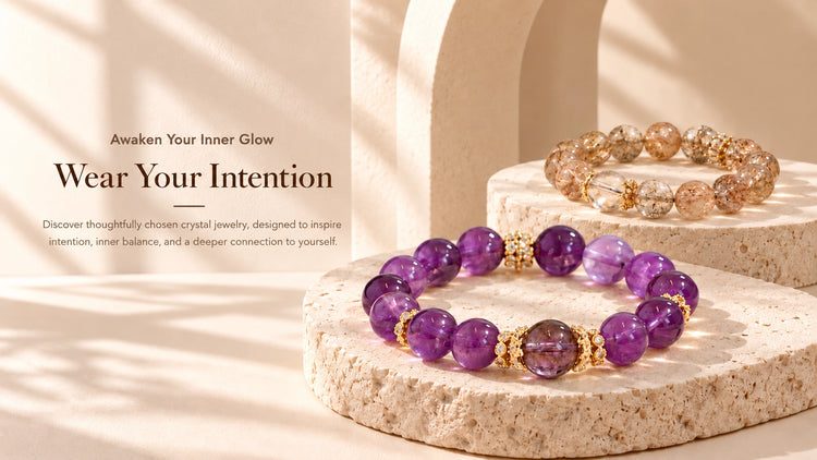 Amethyst and golden-toned crystal bracelets displayed on sculptural ivory stone pedestals