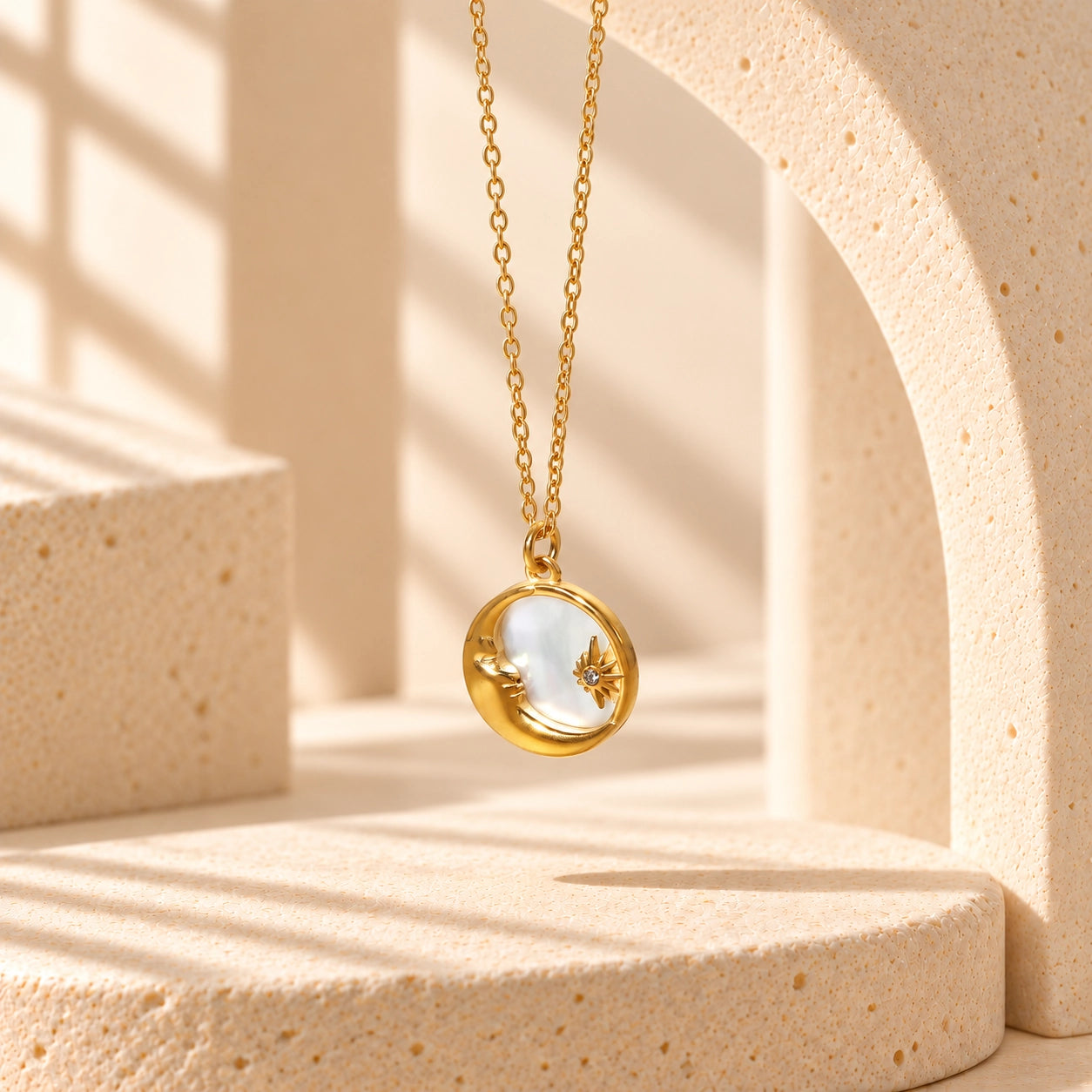 Sun & Moon Shell Necklace with a fine gold-tone chain and luminous shell pendant in an ivory-toned jewelry studio setting