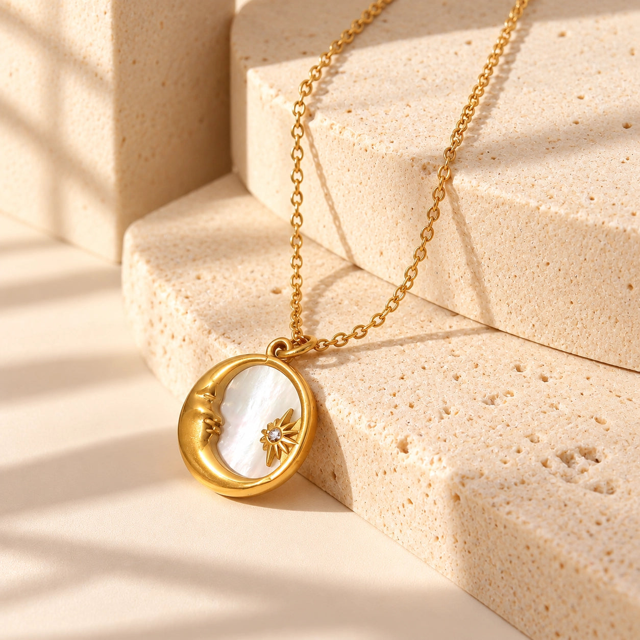 Moon & Star shell necklace with gold-tone crescent moon and star pendant in a minimal warm ivory sculptural studio