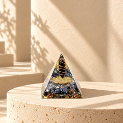 Protection orgonite pyramid with obsidian, labradorite, copper and gold foil styled in warm natural sunlight