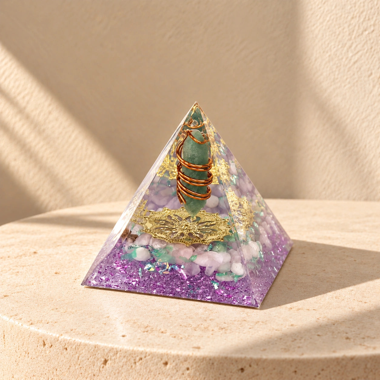 Rose quartz and green aventurine orgonite pyramid with purple resin and copper details in soft natural sunlight