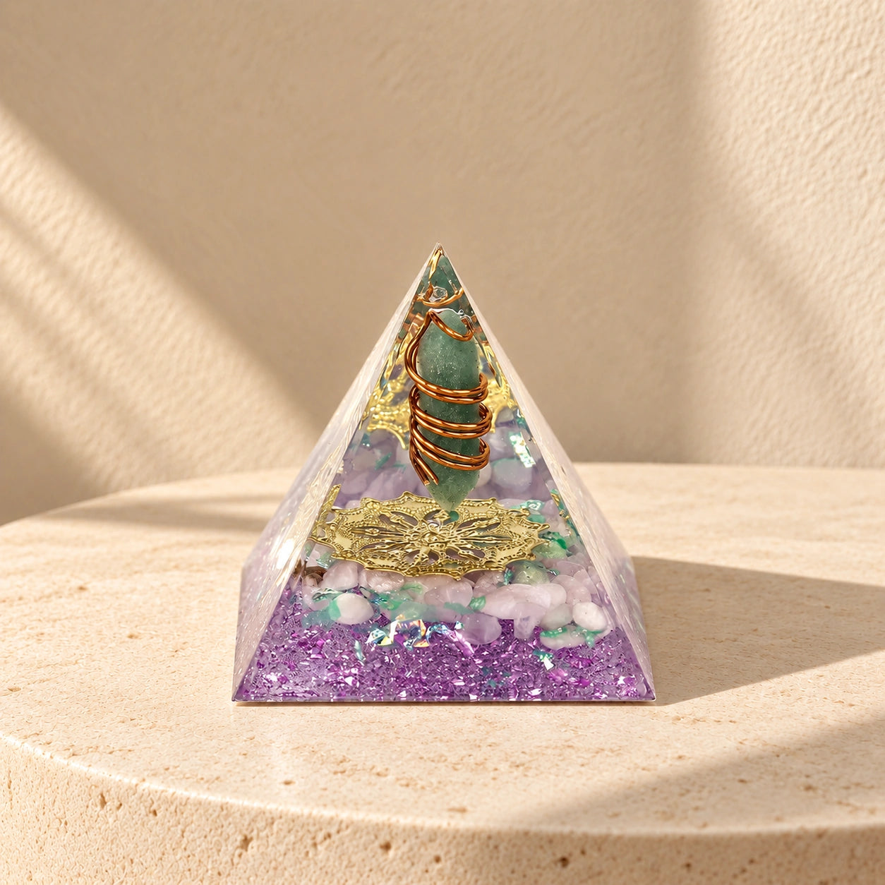 Restore Love orgonite pyramid with rose quartz, green aventurine and copper details on a warm ivory stone surface