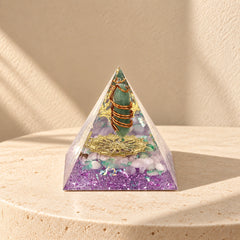 Restore Love orgonite pyramid with rose quartz, green aventurine and copper details on a warm ivory stone surface