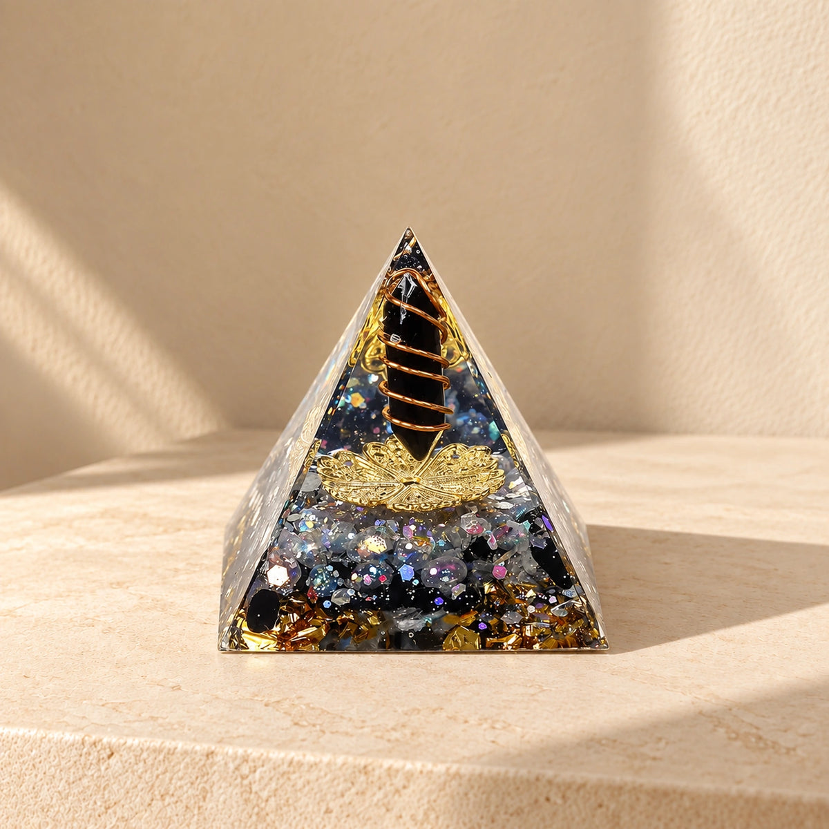 Protection and grounding orgonite pyramid with obsidian and labradorite on a warm ivory stone surface