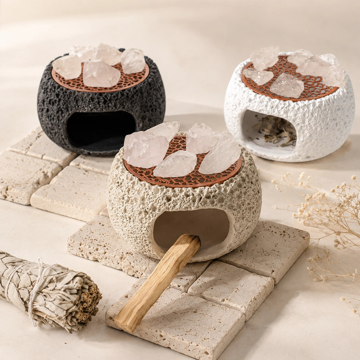 White crystal cleansing burner with palo santo stick, sage bundle, clear quartz stones, and textured ceramic smudge holder