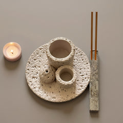 Multi-functional smudge bowl and Palo Santo holder with incense sticks and candle on a neutral background