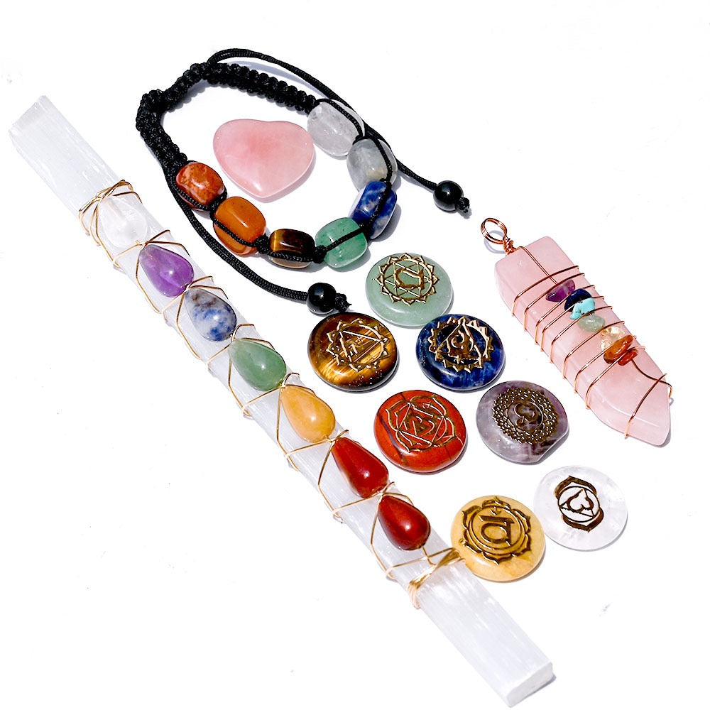 Collection of chakra stones, bracelets, and crystalpendants on a white background