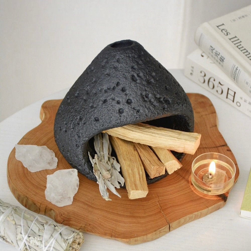 Black ceramic smudge bowl designed for incense and ritual smoke cleansing.