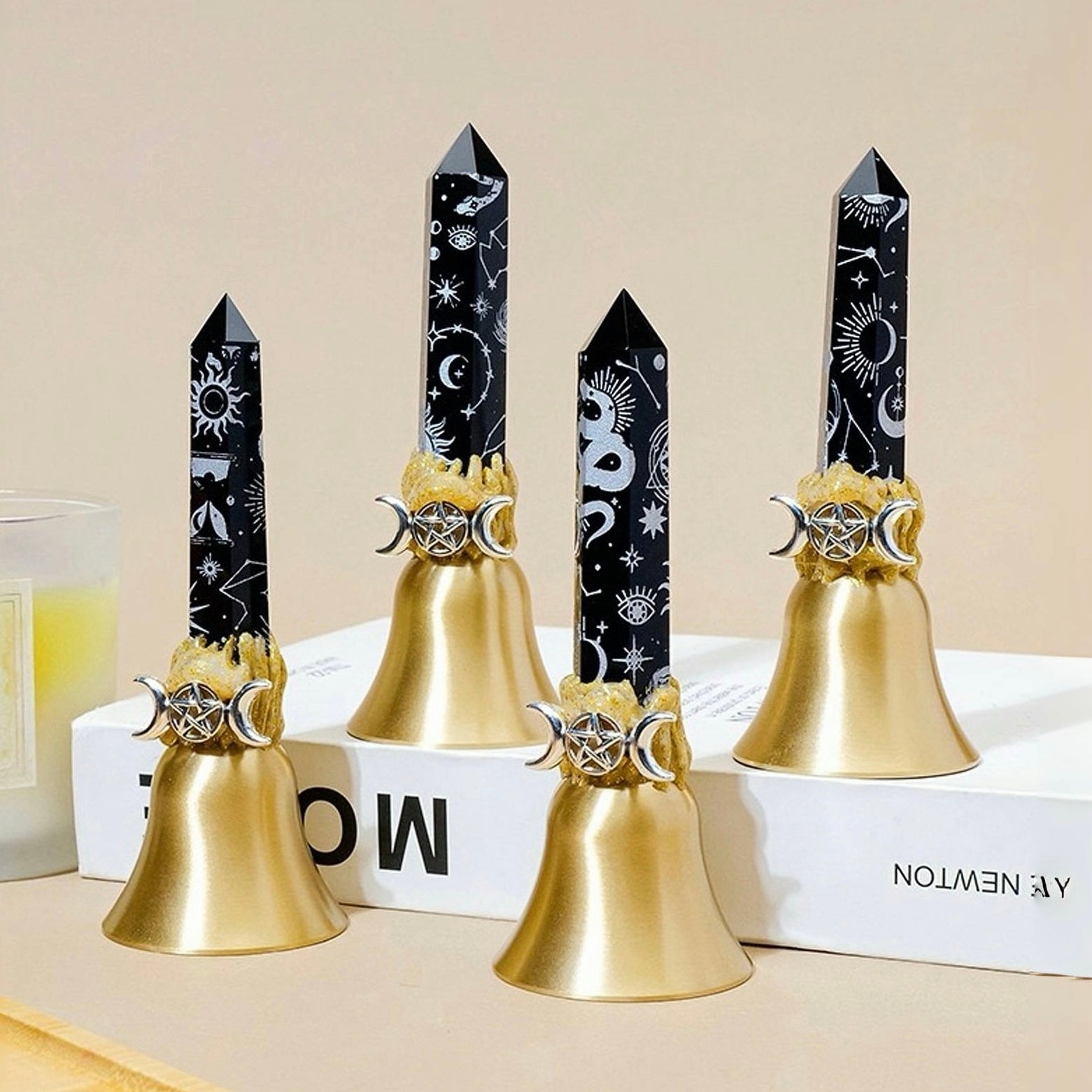 Black celestial obsidian crystal point bell with silver moon and serpent symbols, featuring a polished obsidian crystal point on a gold metal bell base.