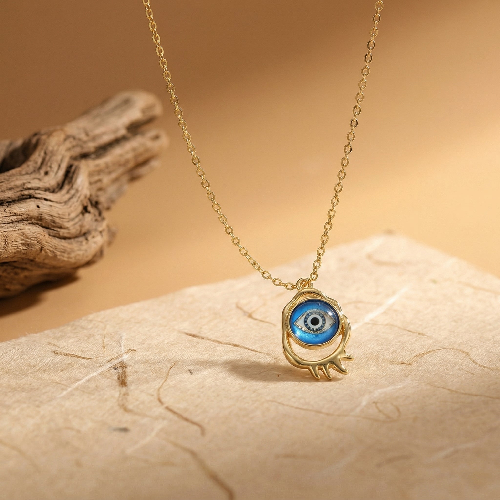 gold evil eye pendant necklace with classic blue eye design on neutral background
