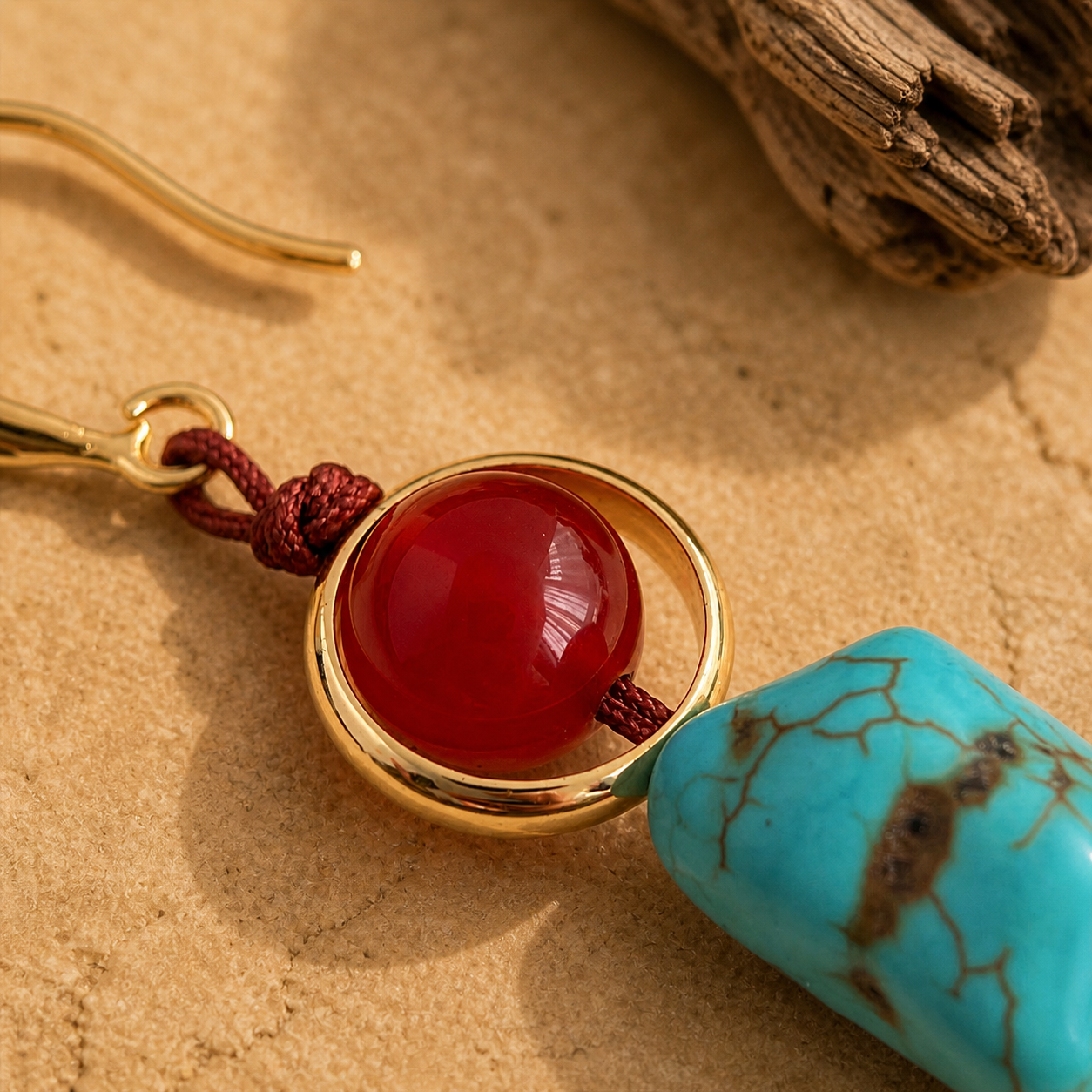 close up of red agate and turquoise handmade earrings with gold tone accents and copper hook