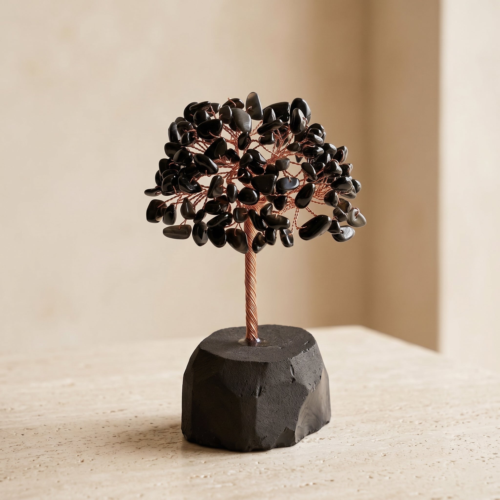 Feng shui crystal tree with black obsidian gemstone leaves and natural black stone base for harmony, luck and protection