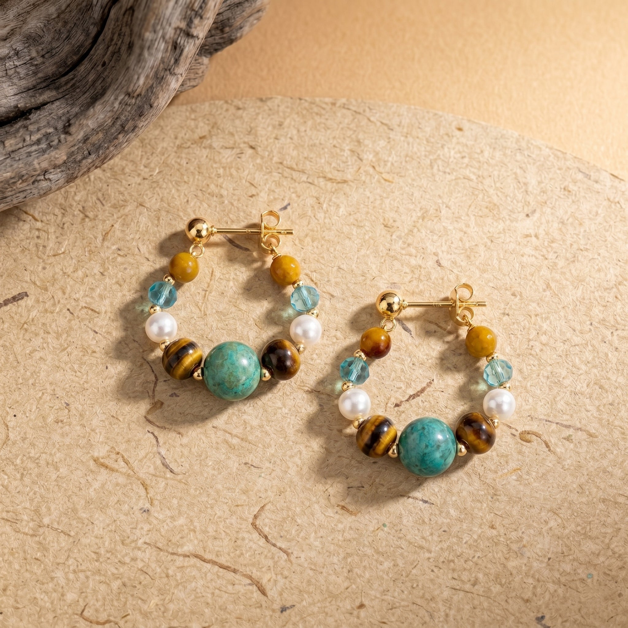 tiger eye and turquoise hoop earrings with colorful gemstone beads on textured stone background
