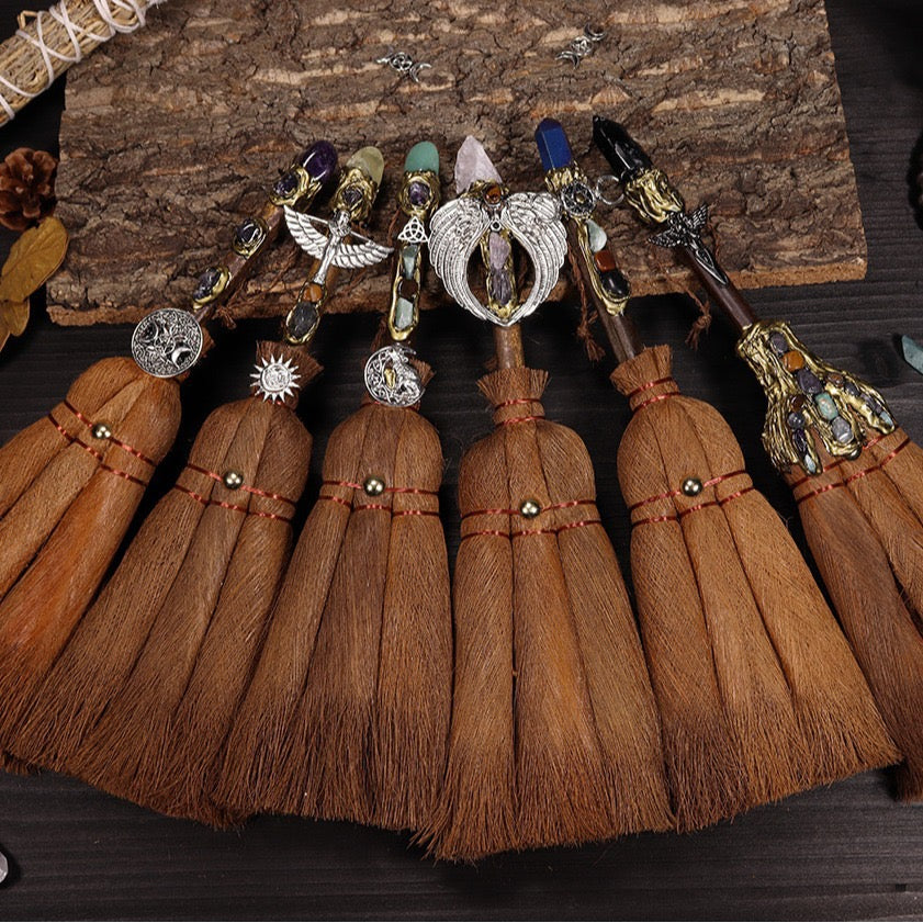 Handmade witch broom with crystal point and symbolic charms for spiritual cleansing