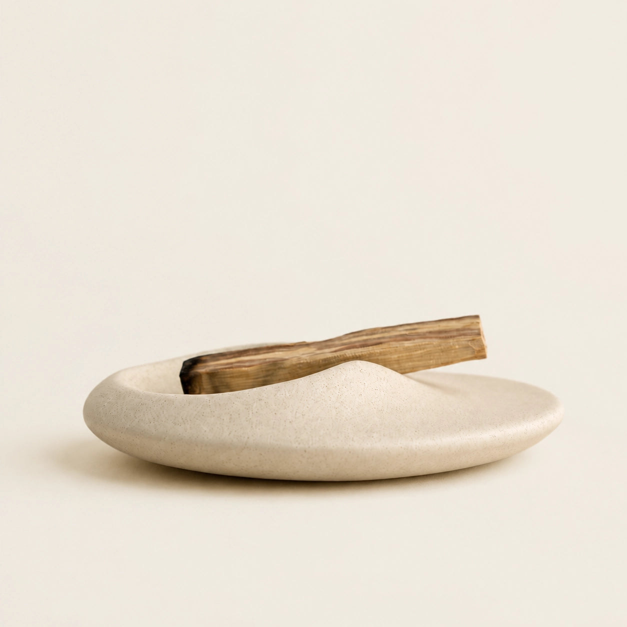 Minimalist Ceramic Palo Santo and Sage Holder with Palo Santo, shallow rounded shape, and natural textured ceramic finish.
