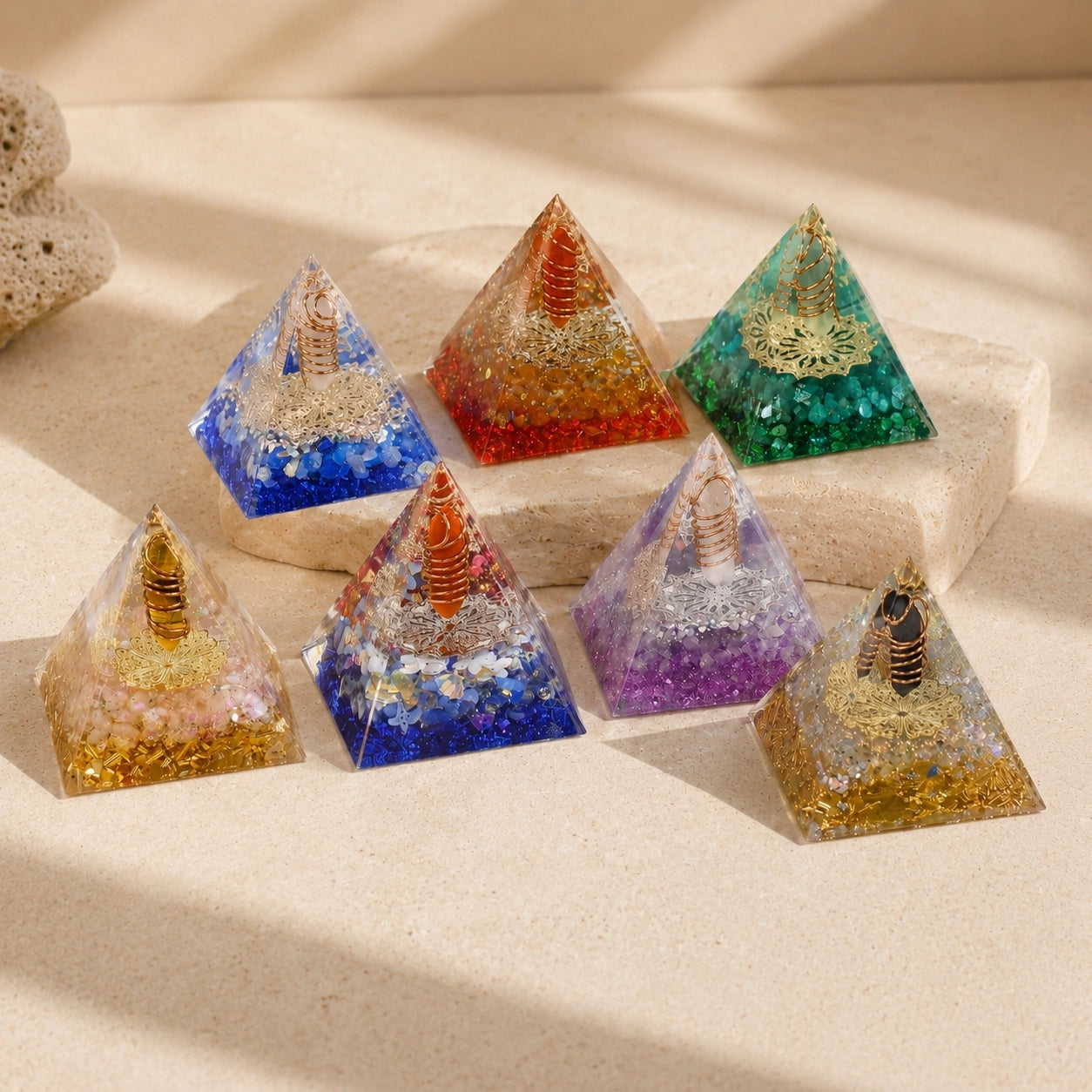 Collection of handmade orgonite energy pyramids in multiple colors with crystal points, copper coils and sparkling resin details