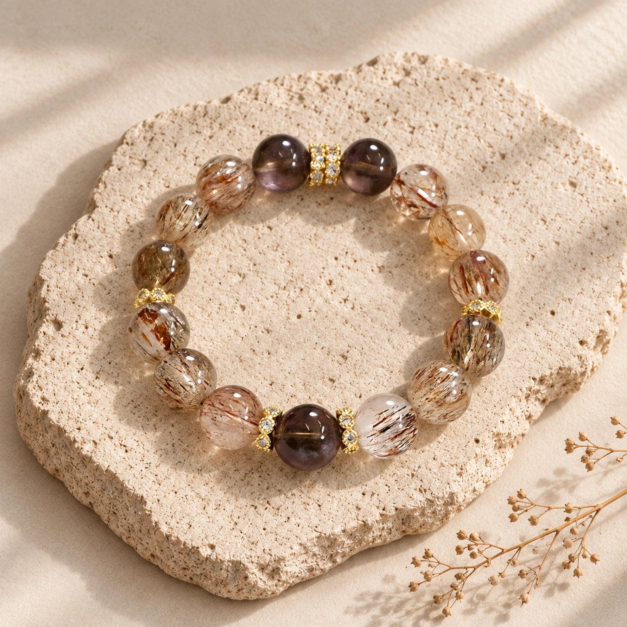 Top-down view of black gold rutilated quartz and smoky quartz polished round beads on a neutral studio background
