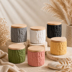 Six textured cement keepsake pet urns with bamboo lids displayed in a warm neutral setting