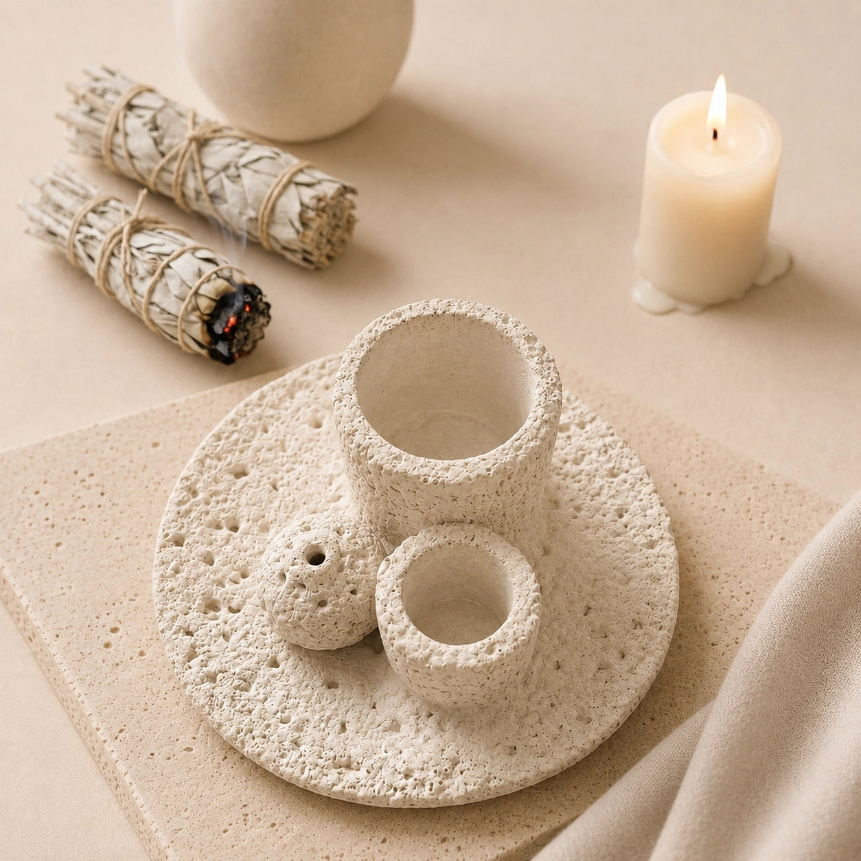 White Wabi-Sabi smudge bowl beside sage bundles and candle in a cleansing ritual setting