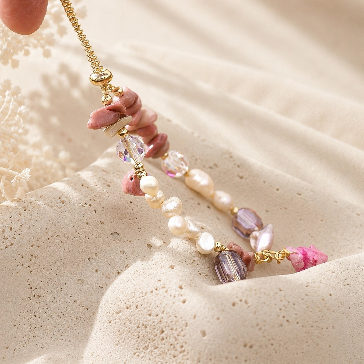Close-up of the gold-tone extender chain on a rhodonite and freshwater pearl bracelet
