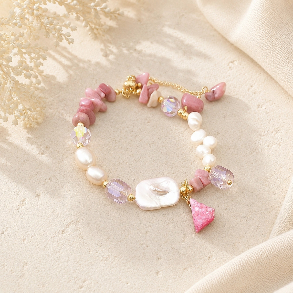 Rhodonite chip and baroque freshwater pearl bracelet with a pink stone charm styled on cream stone