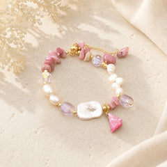 Rhodonite chip and baroque freshwater pearl bracelet with a pink stone charm styled on cream stone