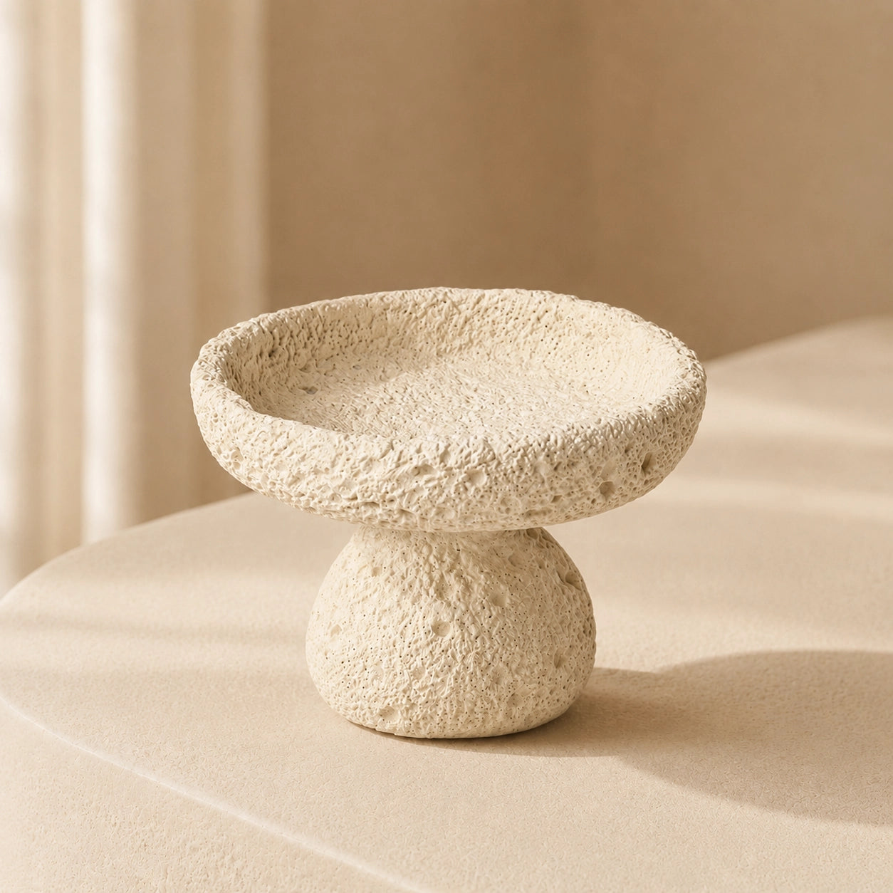 Beige Nordic crystal cleansing bowl in textured cement on a warm minimalist pedestal