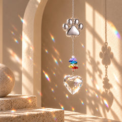 Close-up of reflective silver paw charm and colorful faceted beads on a pet paw crystal suncatcher