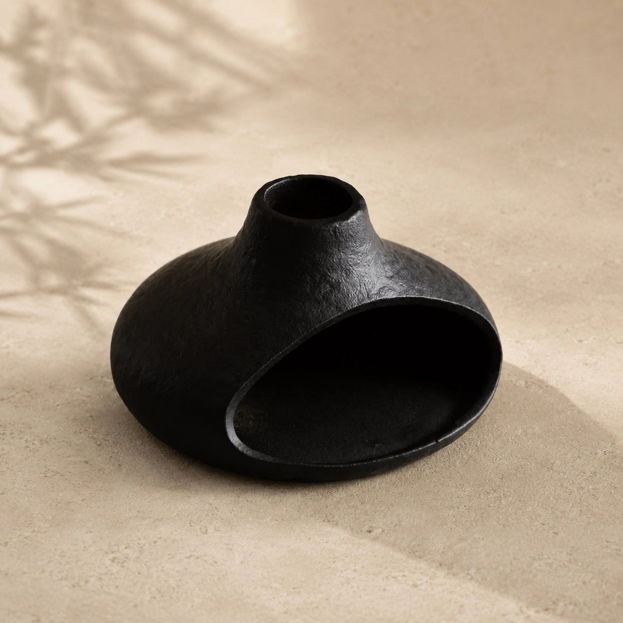 Empty black chimney-style ceramic smudge bowl showing the open front chamber and textured finish
