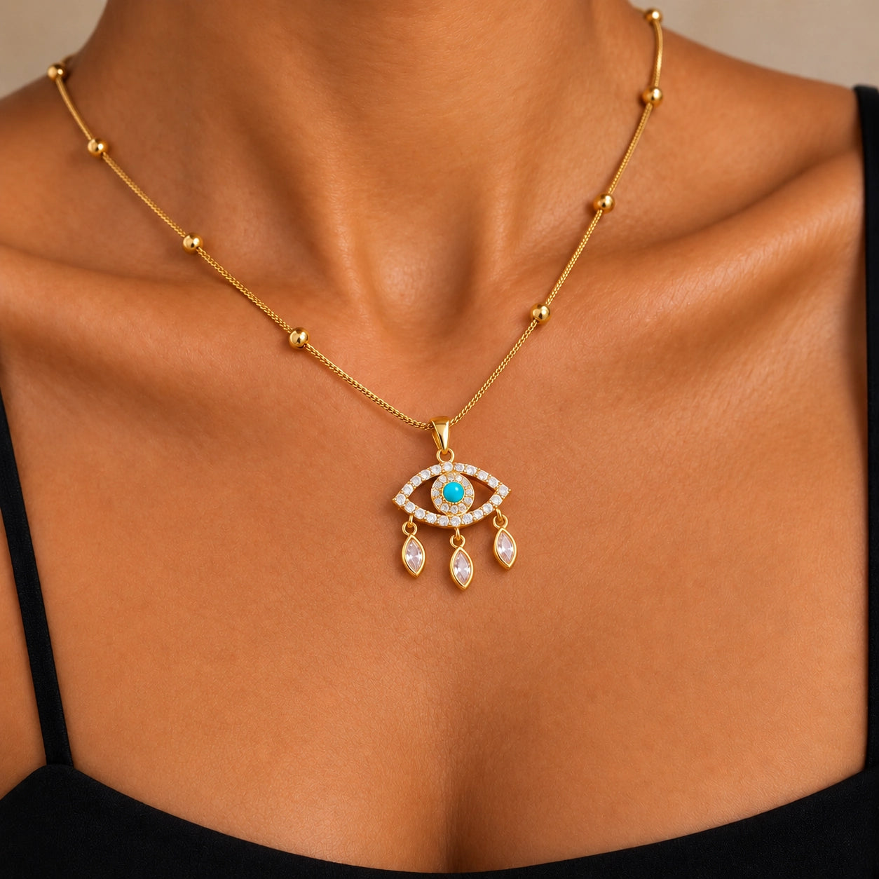 Gold-tone blue evil eye necklace worn around a model's neckline to show size and fit