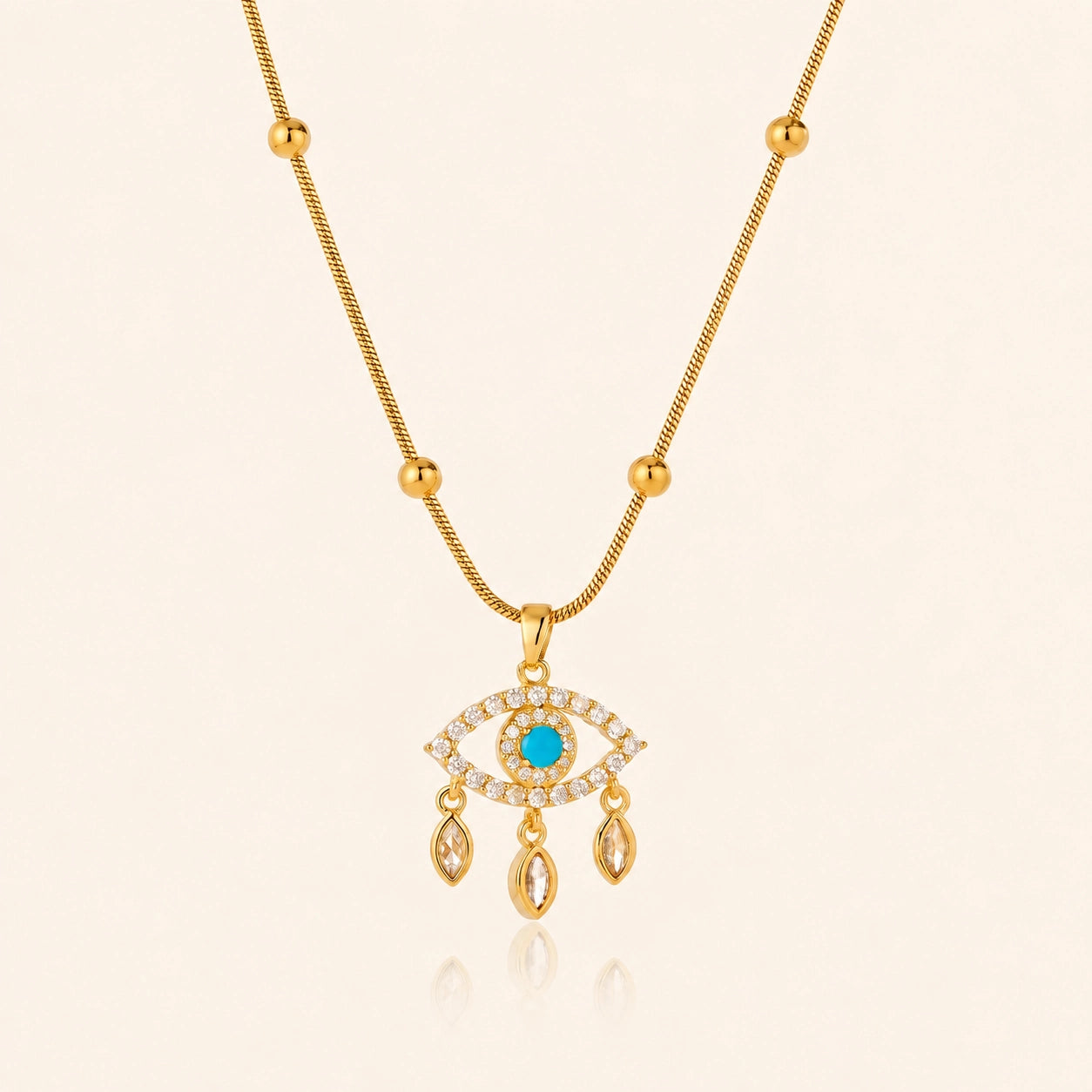 Blue evil eye necklace with polished gold-tone beads against a soft ivory background