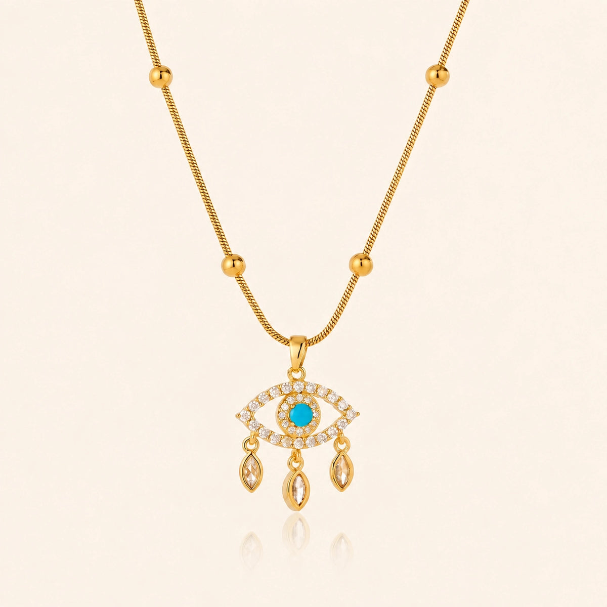 Blue evil eye necklace with polished gold-tone beads against a soft ivory background