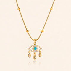 Blue evil eye necklace with polished gold-tone beads against a soft ivory background
