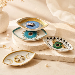 Evil Eye ceramic tray set styled with jewelry and pearls on a neutral stone surface for protective ritual decor