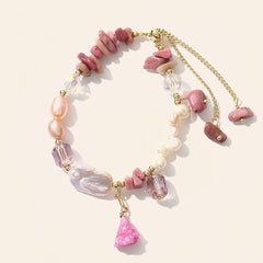 Rhodonite and baroque freshwater pearl bracelet with faceted purple accents, pink stone charm and gold-tone extender on cream