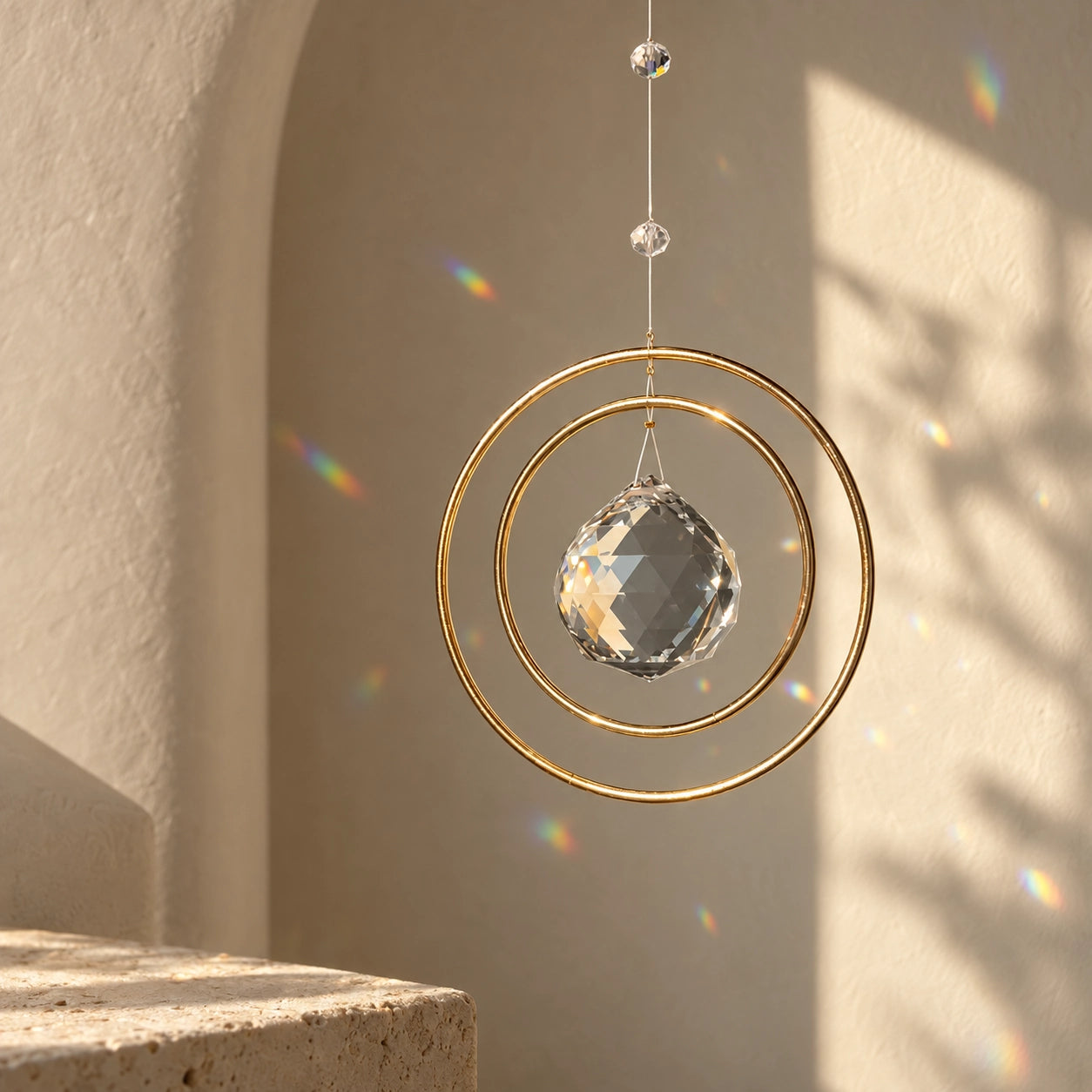 Golden Orbit clear quartz window suncatcher with balanced circular frame and soft rainbow reflections in sunlight