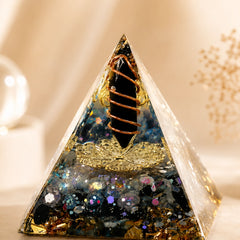 Close-up of a protection and energy shield orgonite pyramid with obsidian point, labradorite chips and copper coil details