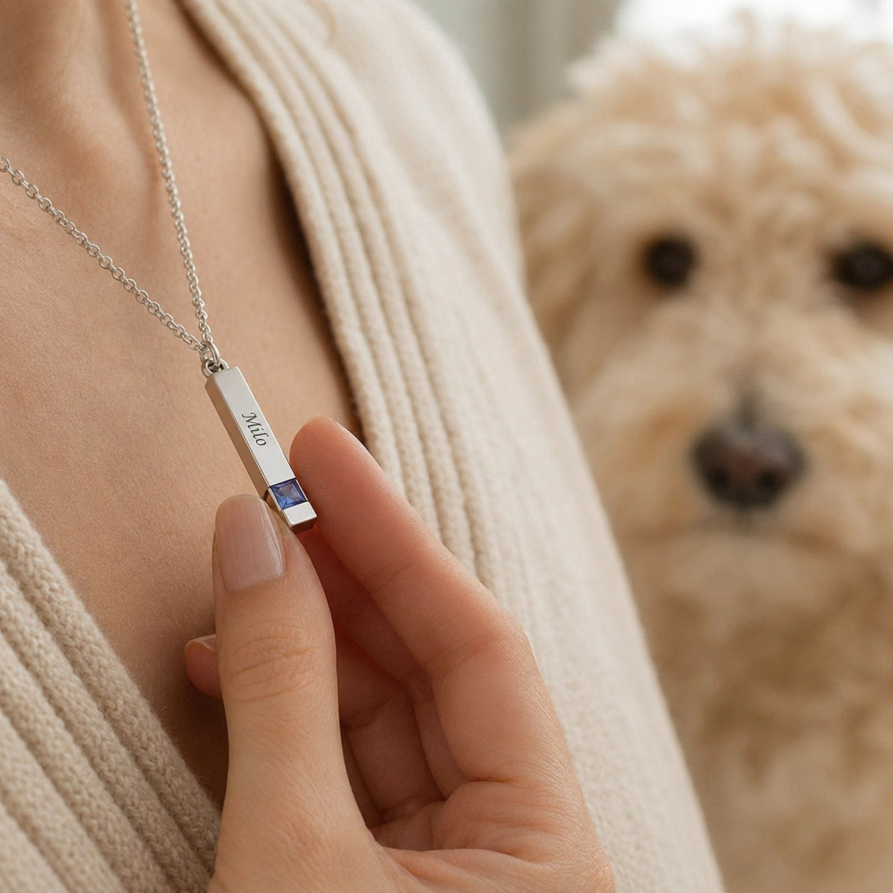 Woman wearing a personalized silver pet memorial necklace engraved with the name Milo