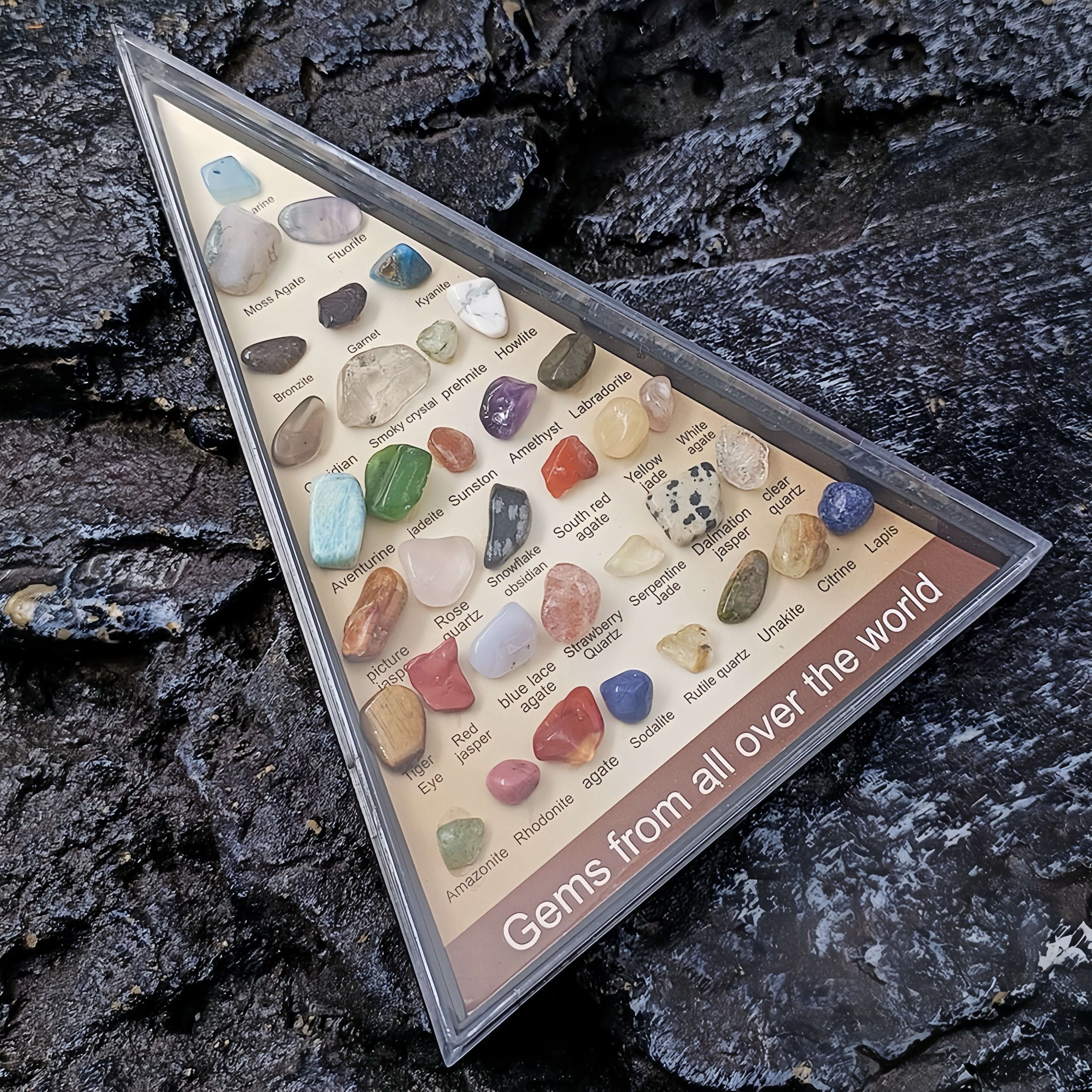 Triangular display case with gemstones on a dark stone background