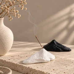 White mountain incense stick holder with black ceramic option in the background and soft incense smoke